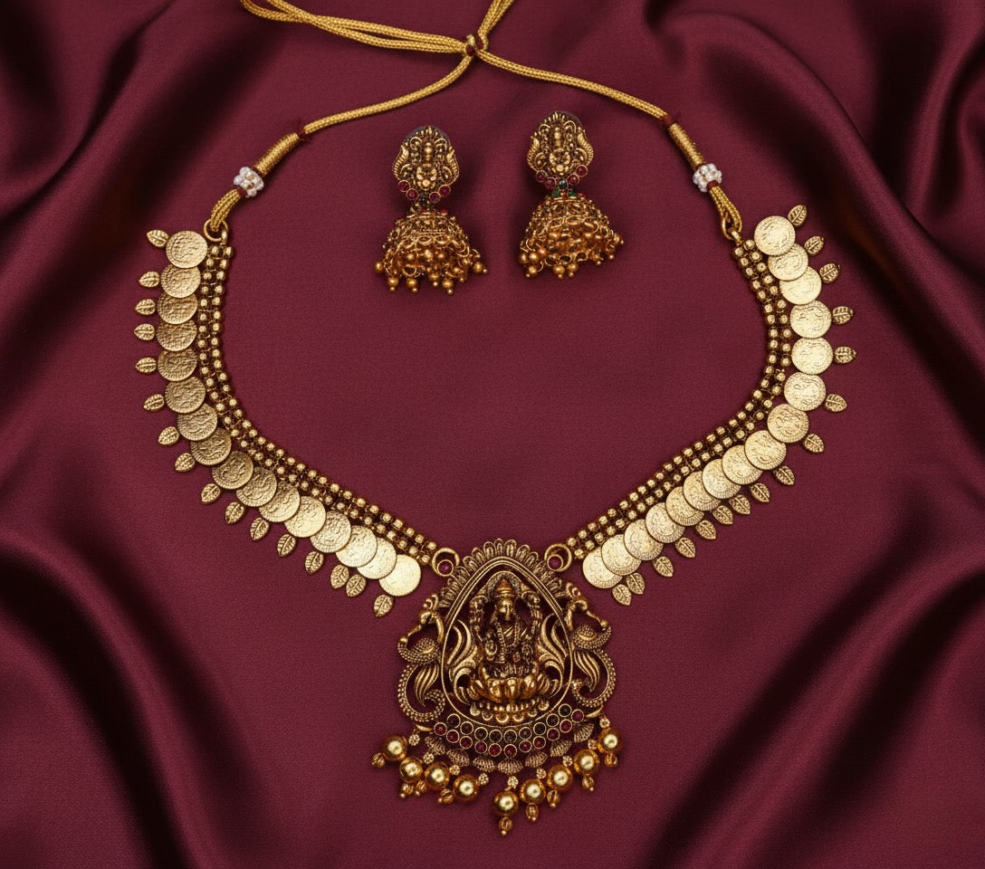 Antique Gold necklace and earrings set on a maroon fabric background